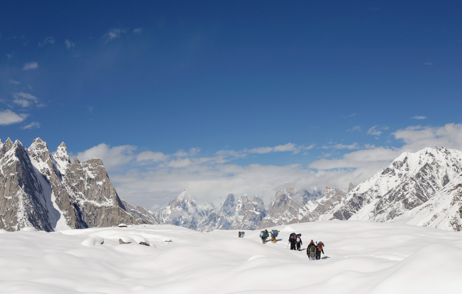 A group of mountain climbers are seen walking through deep snow. (Photo: Reuters)