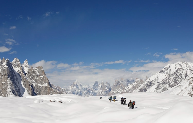 A group of mountain climbers are seen walking through deep snow. (Photo: Reuters)