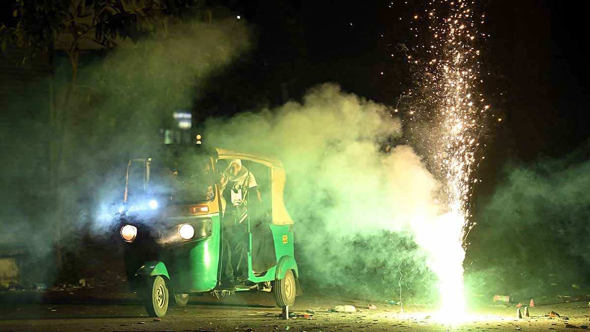 An autorickshaw drives throguh smoke from Diwali firecrackers. (Photo: PTI)