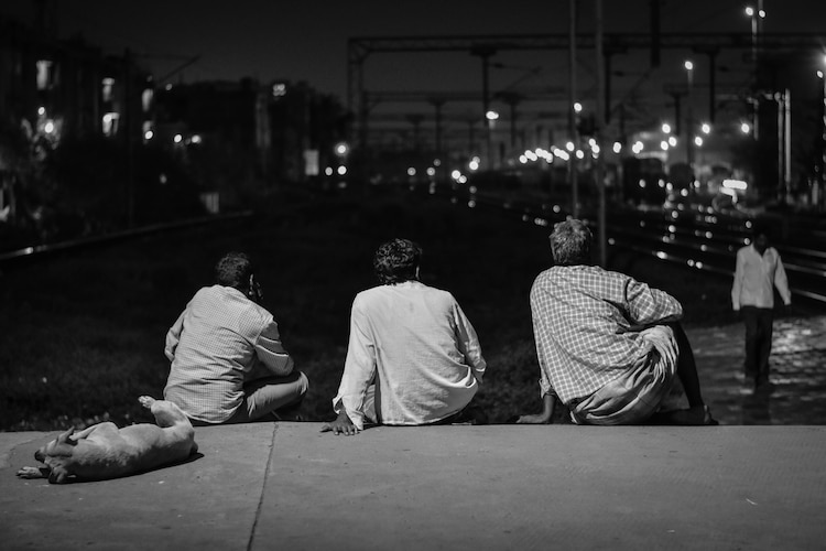 People and a dog rest on a concrete platform in Chennai. (Photo: Unsplash)