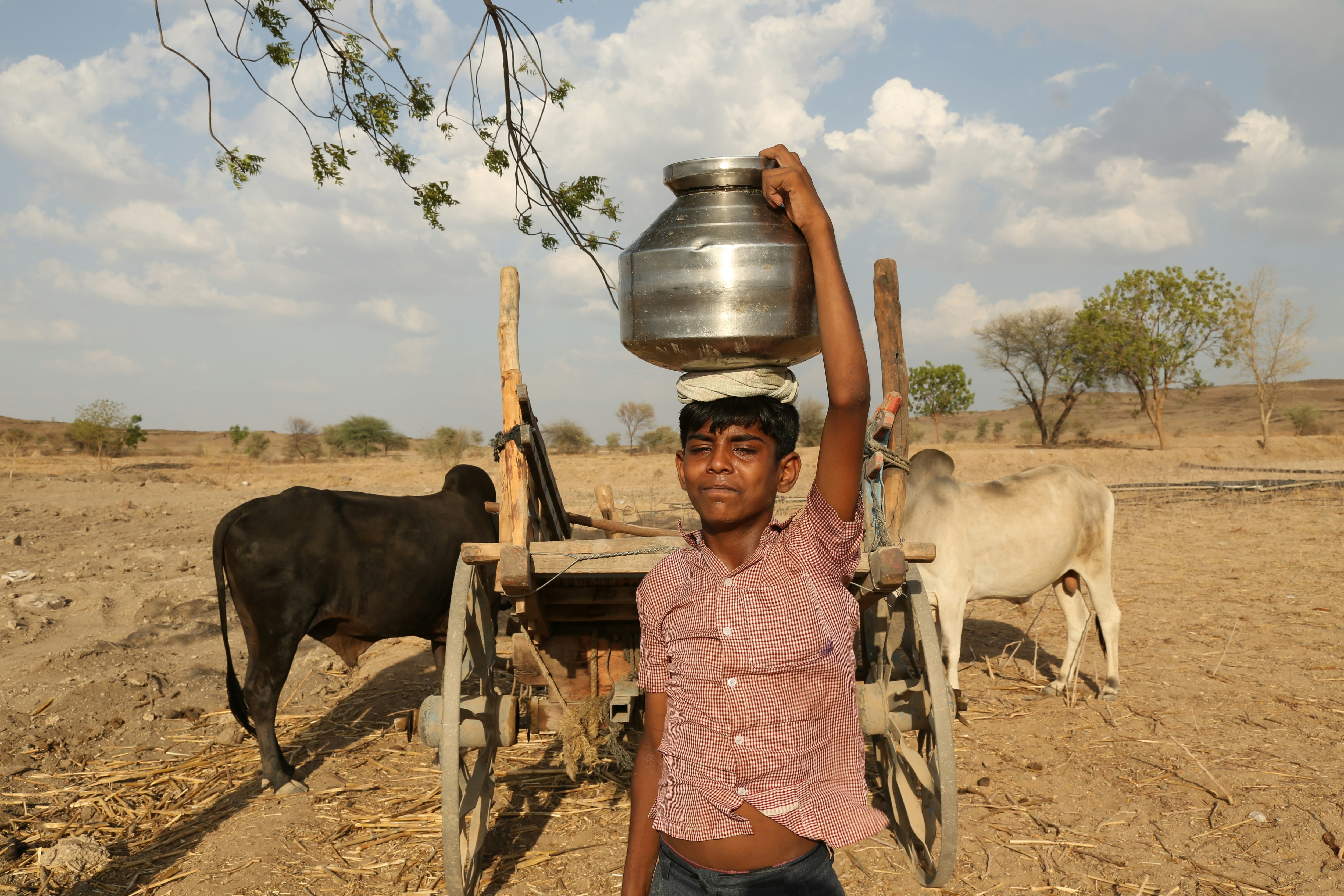 A boy carries water from a well during a hot day in Dhule, Maharashtra. (Photo: Unsplash)