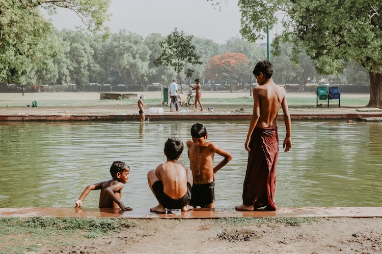 Young boys bathe in a river new India gate, Delhi, to beat the heat. (Photo: Unsplash)