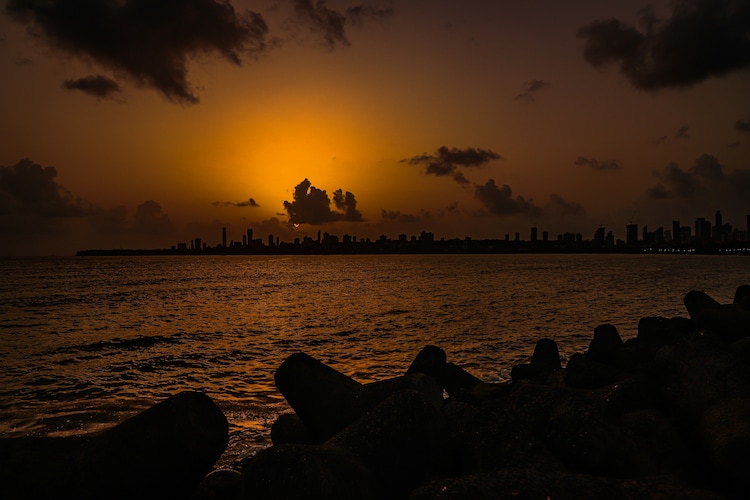 The Sun is seen setting above the Mumbai skyline. (Photo: Unsplash)
