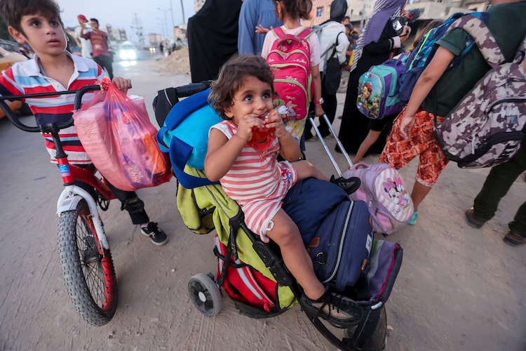 Palestinian children wait with their families fleeing Bureij as the Israeli army orders them to evacuate the area, amid the Israel-Hamas conflict, in the central Gaza Strip, July 28, 2024. (Photo: Reuters)