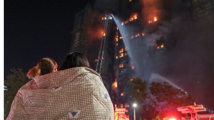 Residents watch flames engulf bamboo scaffolding at Wang Fuk Court housing estate after a major fire broke out in Hong Kong. (Photo: Reuters)
