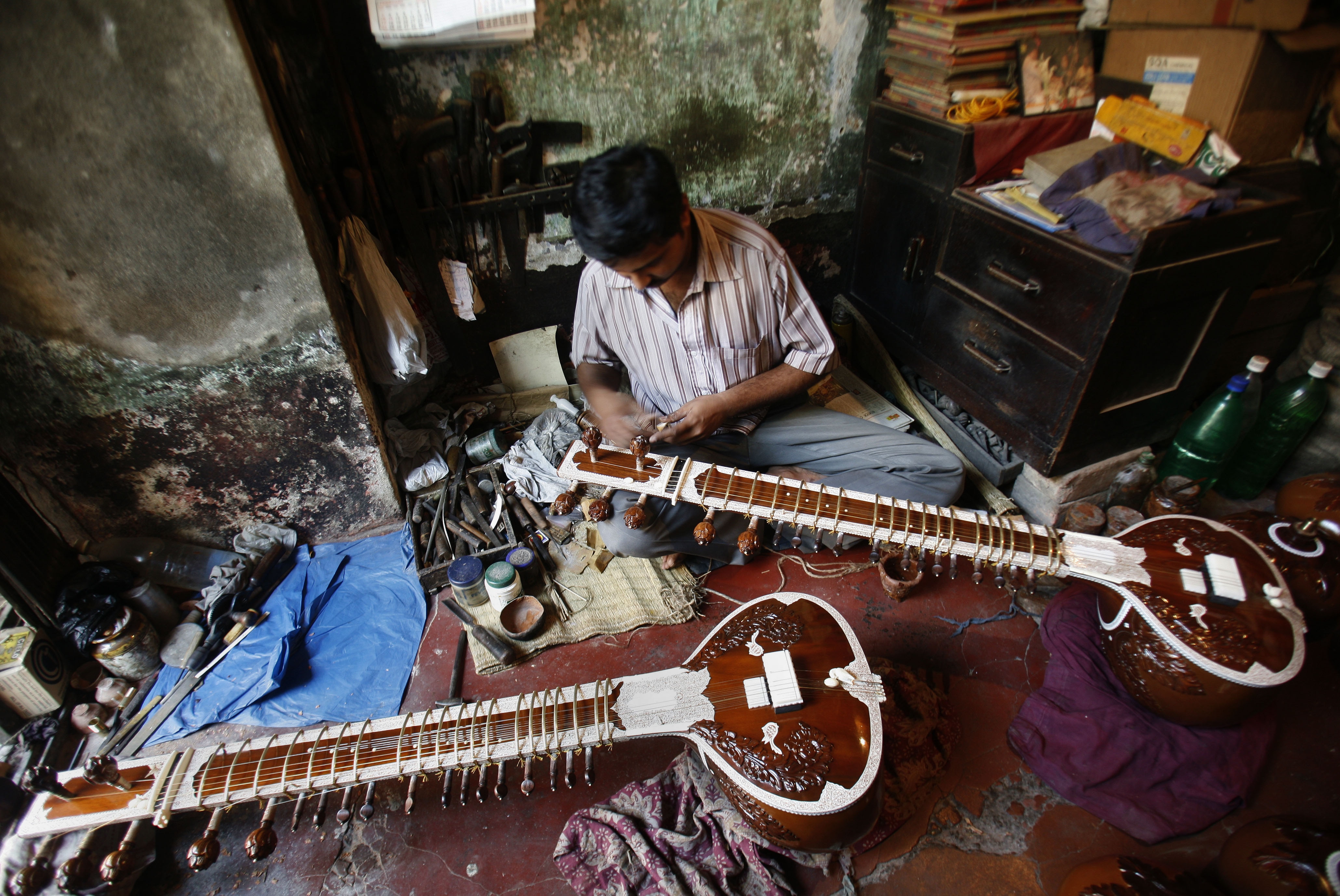 Suman Karmakar, an Indian instrument maker, works on a sitar inside a 50-year-old shop in the eastern Indian city of Kolkata. (Photo: Reuters)