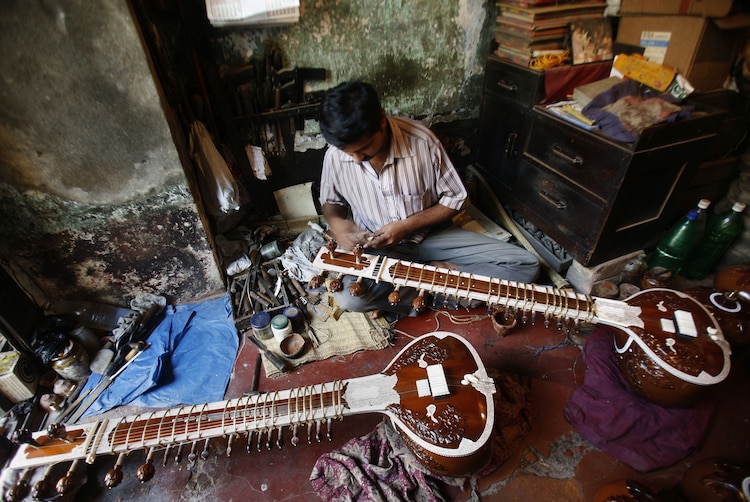 Suman Karmakar, an Indian instrument maker, works on a sitar inside a 50-year-old shop in the eastern Indian city of Kolkata. (Photo: Reuters)