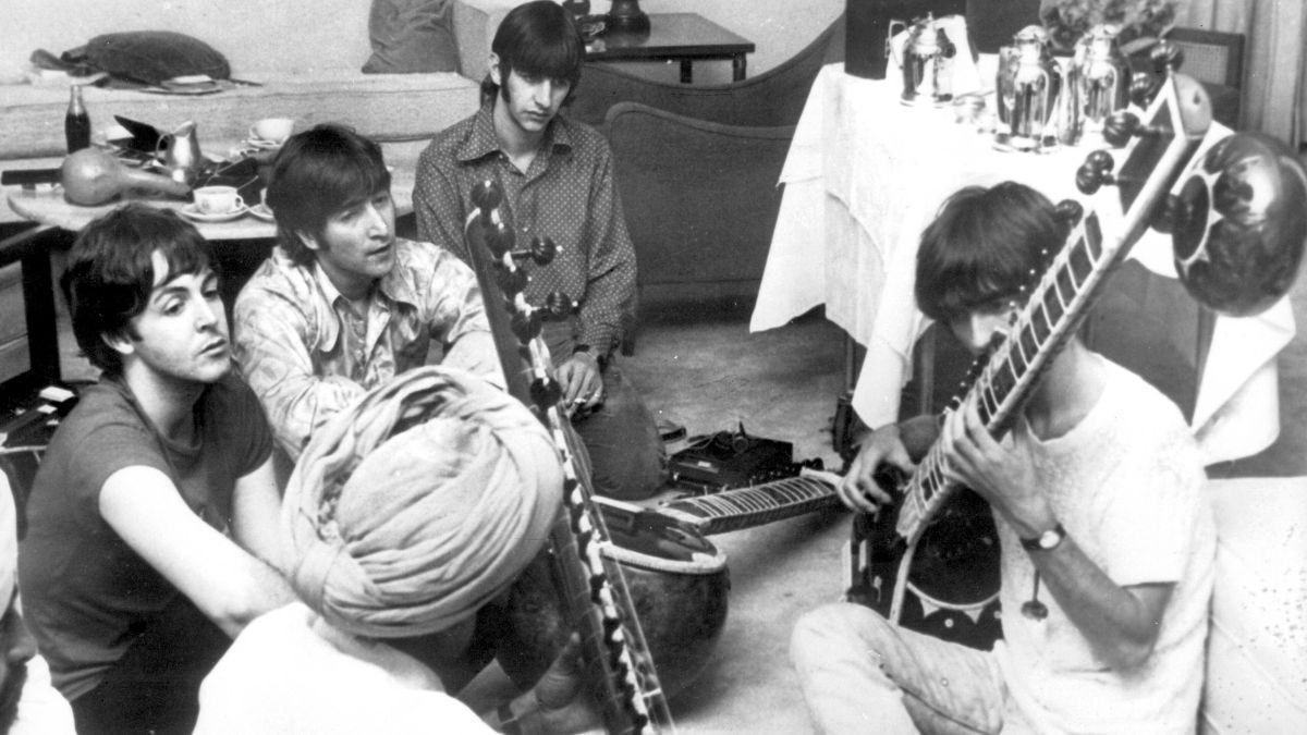 George Harrison receives a sitar lesson in New Delhi, with Paul McCartney and John Lennon looking on. (Photo: X)