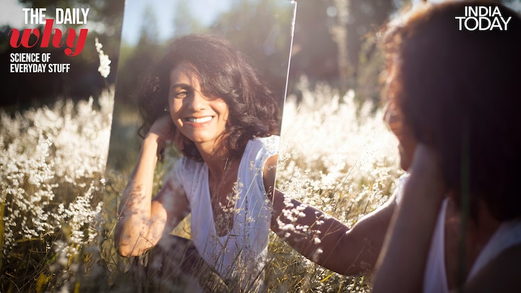 A woman looking at herself in a mirror. (Photo: Unsplash)