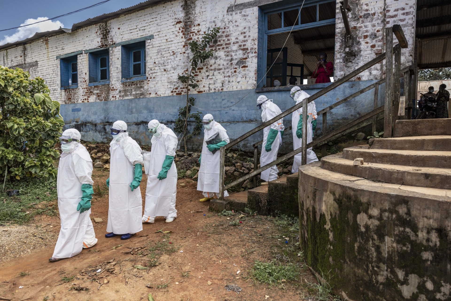 Health workers wearing protective equipment walk outside the General Referral Hospital during the Ebola outbreak response