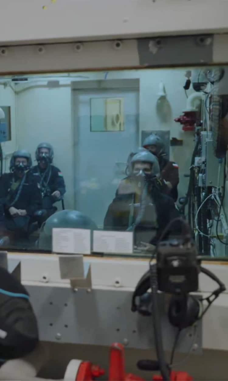 Axiom-4 crew members wearing helmets and oxygen masks undergo controlled low-oxygen exposure inside the altitude training facility, learning to recognise hypoxia symptoms firsthand. (Photo: X/@gaganshux)