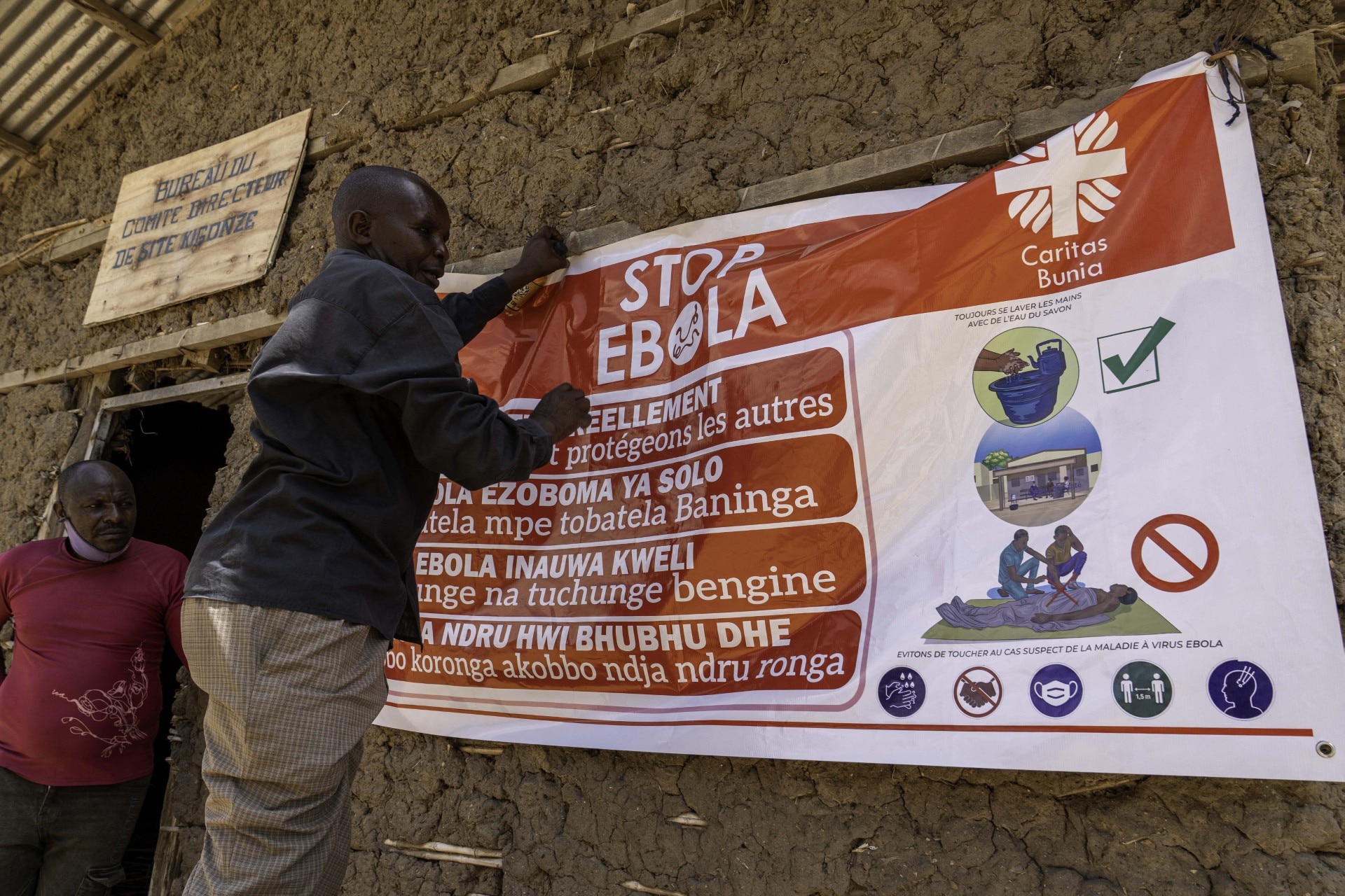A man hangs an Ebola awareness banner in the Kigonze camp in Bunia, in the eastern Democratic Republic of the Congo