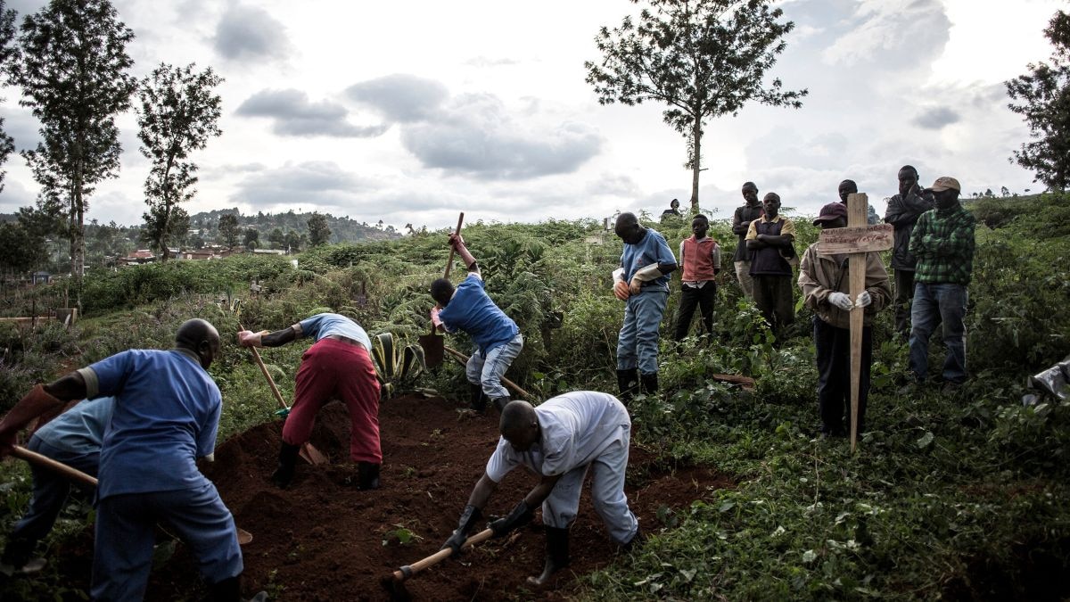 Family members look on as they watch the deceased victims of the Ebola virus being buried on May 16, 2019 in Butembo. (Photo: AFP)