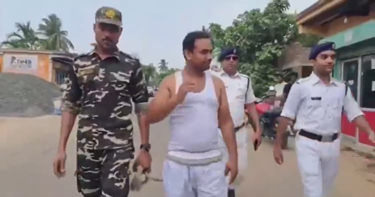 Sahin Molla, a former Home Guard and alleged extortionist, was paraded by police and central forces in Howrah while wearing a tank top and shorts. (Image: Screengrab from Social Media)