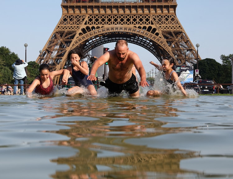 People cool off in the Trocadero Fountain next to the Eiffel Tower in Paris