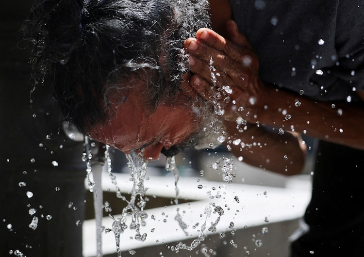A man washes his face to cool off during a hot day amid a heatwave in Madrid, Spain. (Photo: Reuters)