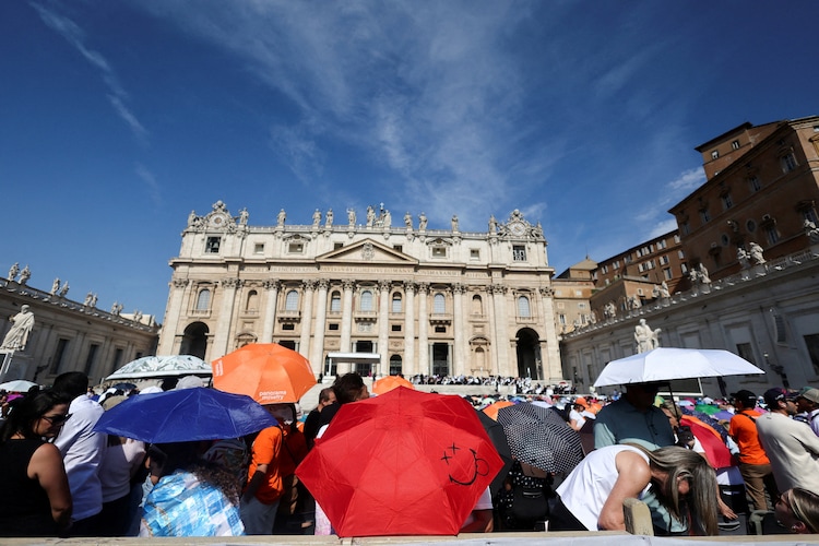 People shelter from the sun under umbrellas on the day Pope Leo holds the weekly general audience in St. Peter's Square at the Vatican.