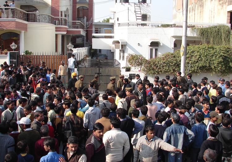 A crowd gathered near Moninder Singh Pandher's house in Nithari village, Noida as bones and others parts of human body found in a drain near Pandher house