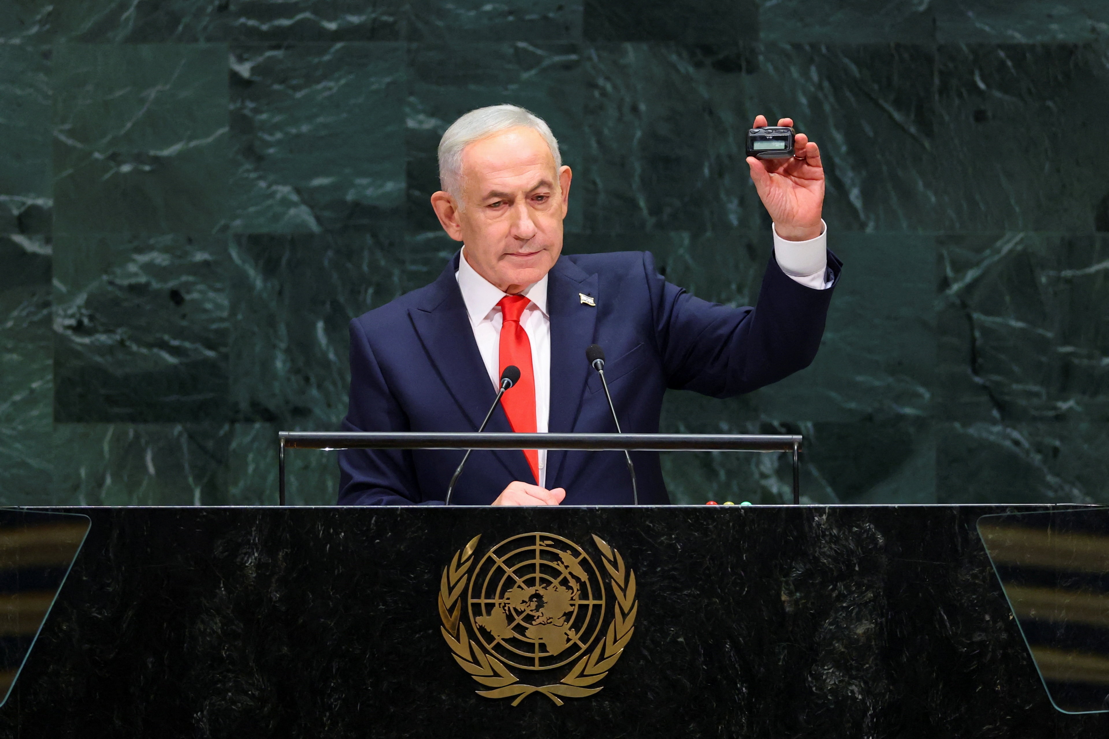 Benjamin Netanyahu holds up a pager as he addresses the 81st United Nations General Assembly.