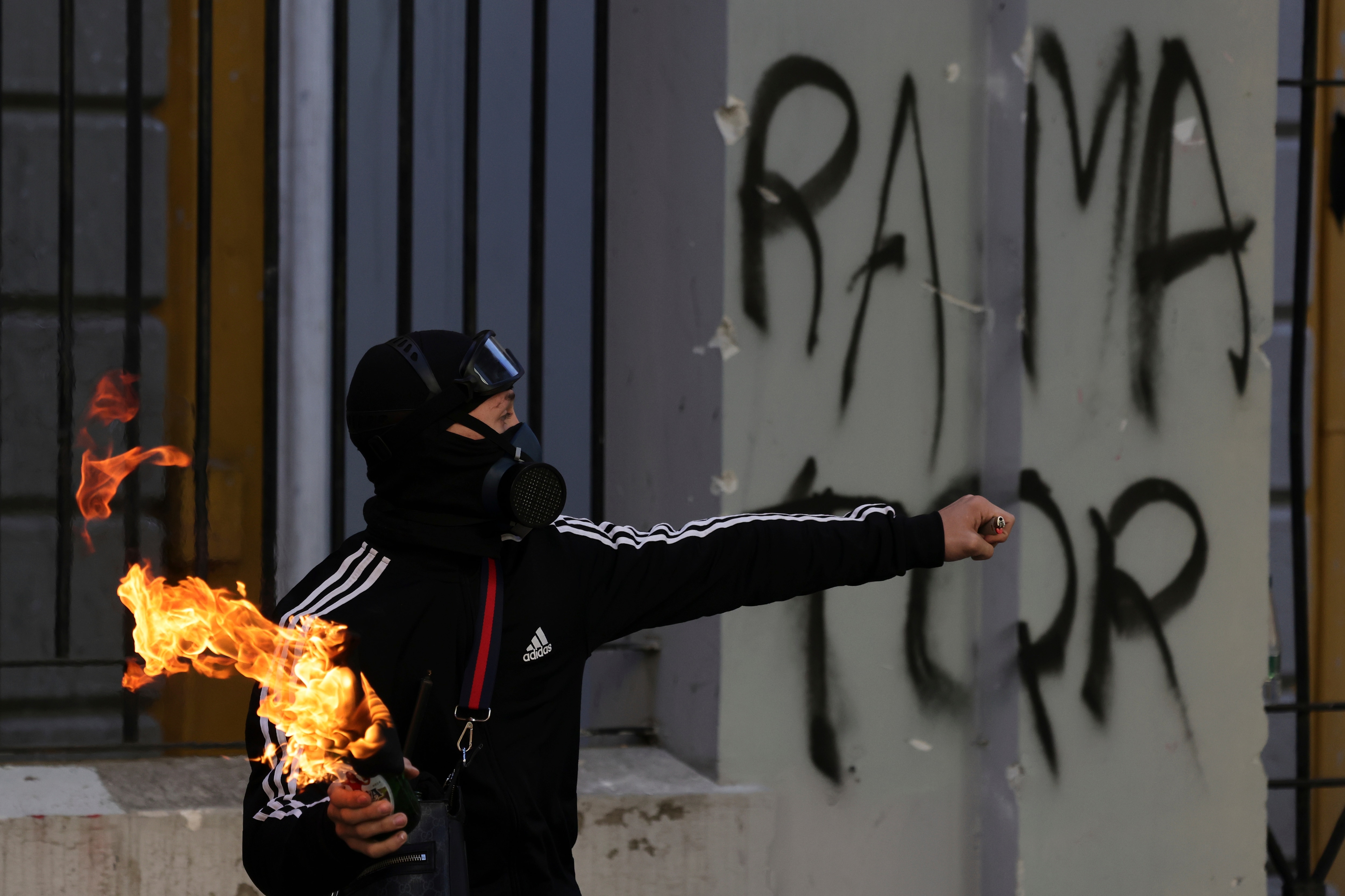 A protester prepares to throw a petrol bomb at riot police in Tirana, Albania, on October 18. (AP Photo)