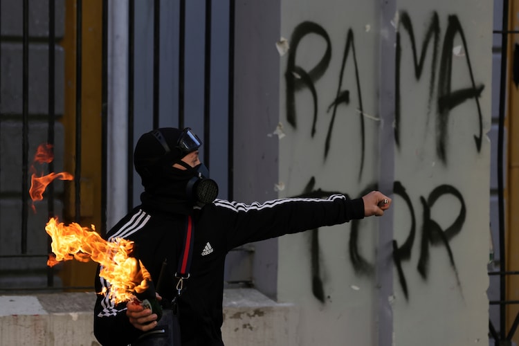 A protester prepares to throw a petrol bomb at riot police in Tirana, Albania, on October 18. (AP Photo)
