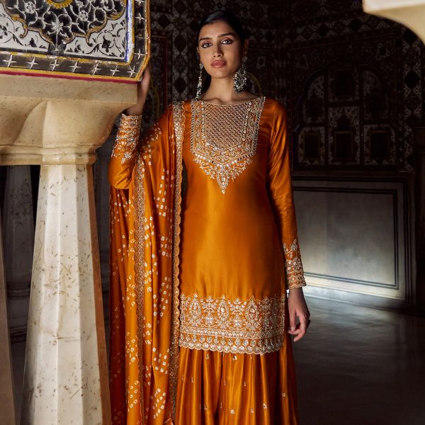 https://akm-img-a-in.tosshub.com/lingo/brt/images/photo_gallery/202510/lashkaraa_orange_shantoon_crepe_sequins_zari_embroidery_bandhani_kurta_sharara_set_rs26100.jpg