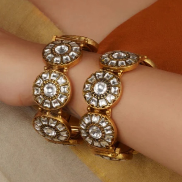 https://akm-img-a-in.tosshub.com/lingo/brt/images/photo_gallery/202602/mortantra_white_color_gold_plated_thappa_jadau_kundan_bangles_rs10000.png