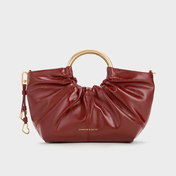 https://akm-img-a-in.tosshub.com/lingo/brt/images/photo_gallery/202603/charles_and_keith_ciara_ruched_metal_top_handle_bag_rs10999.png