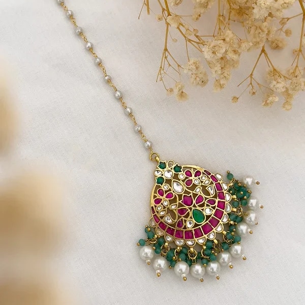 https://akm-img-a-in.tosshub.com/lingo/brt/images/photo_gallery/202610/ishhaara_real_kemp_jadau_kundan_swarovski_pearls_maang_tikka_rs7900.png