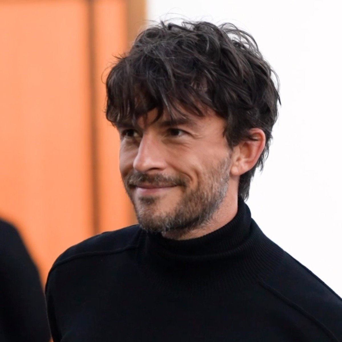 Jonathan Bailey brought his signature charm to London Fashion Week in a slick black ensemble