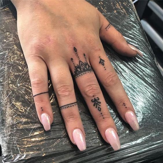 Close-up image showcasing intricate finger tattoos with detailed linework.