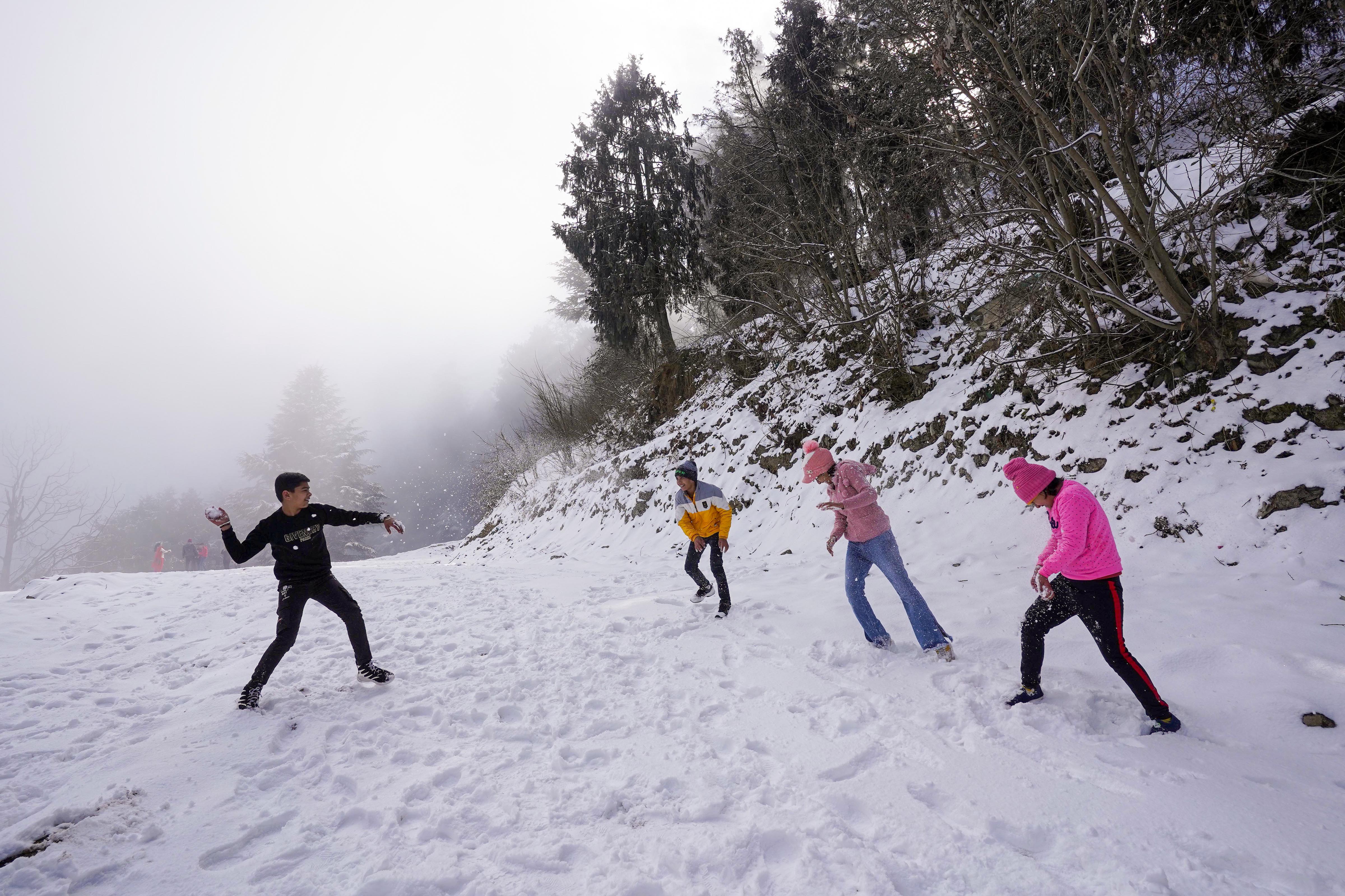 बर्फबारी का लुत्फ उठाते सैलानी