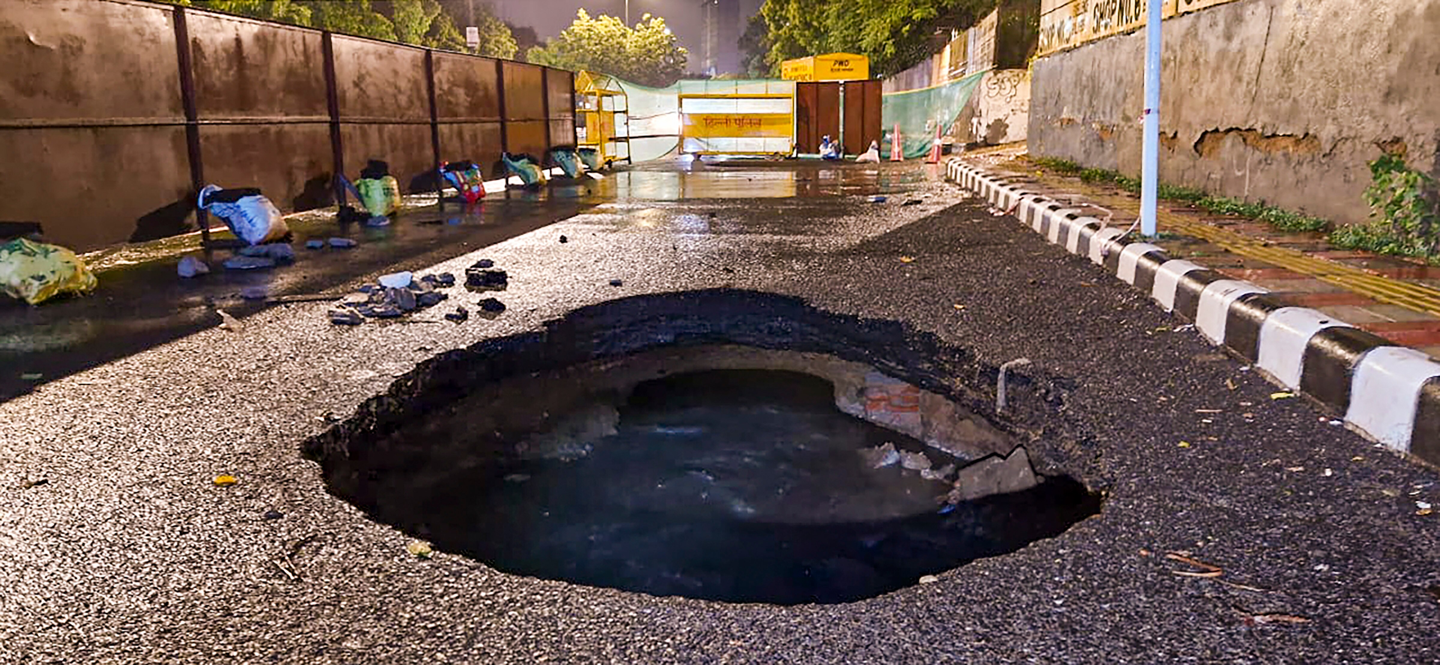 A caved in portion of a road near Hauz Khas after heavy rainfall (PTI Photo)