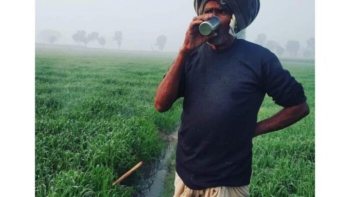 घने कोहरे में फसल को पाला पड़ने से बचाने के उपाय करता किसान