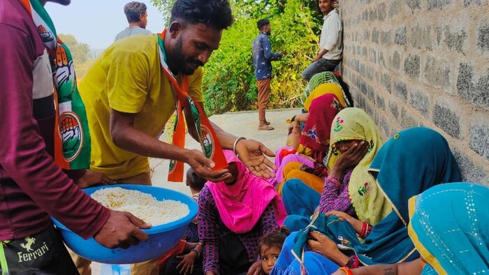 आदिवासी लोगों को नाश्ता बांटते हुए