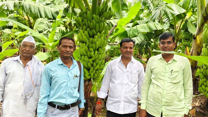 खेत में केले की फसल दिखाते हुए थलकरी परिवार