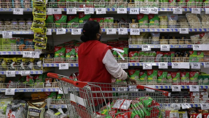 A worker arranges goods in a Reliance supermarket in Mumbai