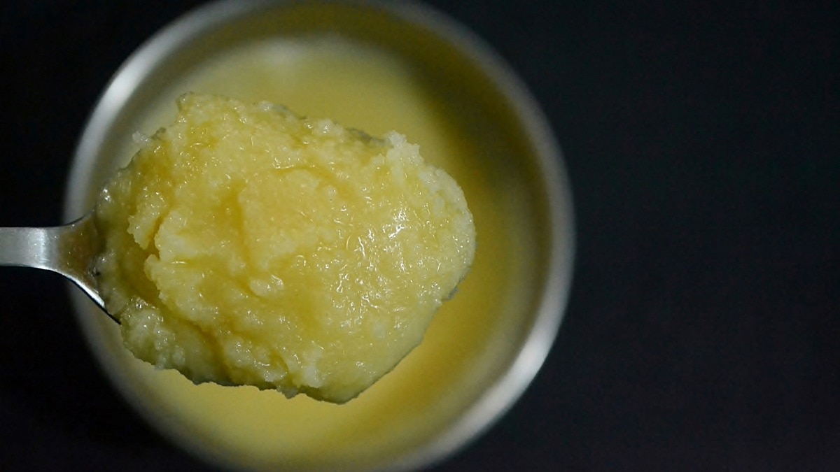 Homemade pure ghee in a spoon and container.