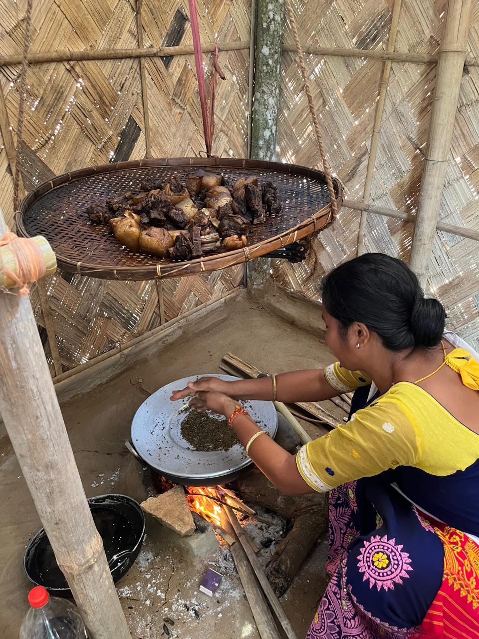 Nayana making oma narzi or smoked pork with jute leaves, a Bodo dish