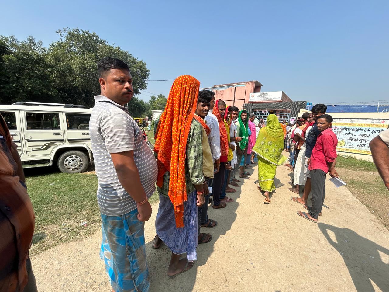 गौछारी पार में मतदान केंद्र के बाहर लाइन लगाए पुरुष मतदाता