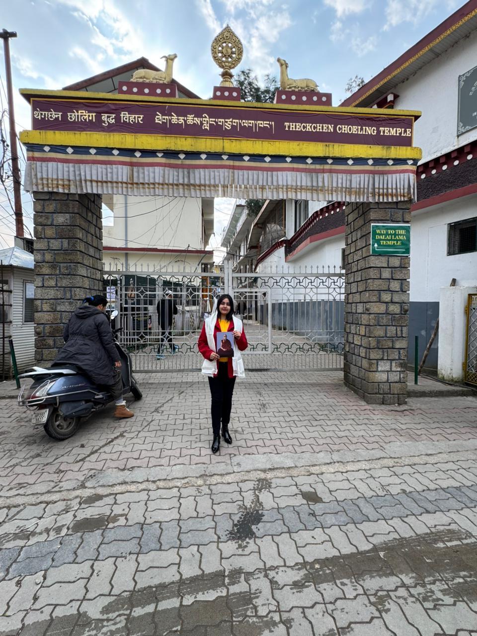 My daughter outside the Theckchen Choeling Temple holding His Holiness Dalai Lama's image