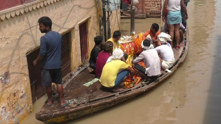 वाराणसी: महाश्मशान मणिकर्णिका घाट डूबा, नाव से शव ले जा रहे परिजन, ऐसे हो रही अंत्येष्टि UP Tak