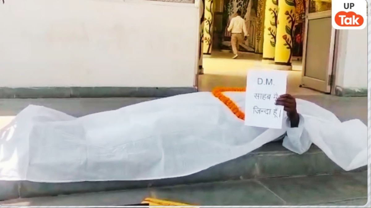 बस्ती में DM दफ्तर के बाहर कफन ओढ़कर लेट गए इशहाक अली, बोले-'साहब कागजों में मर चुका हूं मुझे जिंदा कर दीजिए'