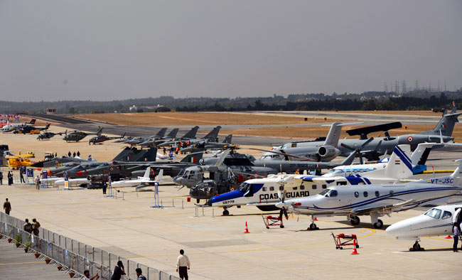 Visitors look at helicopters and aircraft parked on the tarmac of Bangalore's Yelahanka Air Force Station, as part of Aero 2013. (Photo: Nilotpal Baruah)