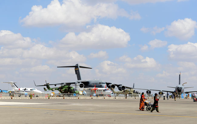 Visitors look at helicopters and aircraft displayed on the tarmac of Bangalores Yelahanka Air Force Station, as part of Aero 2013. The air show will run from February 6 to 10. (Photo: Nilotpal Baruah)