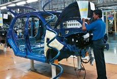 A worker reads assembly instructions for the car