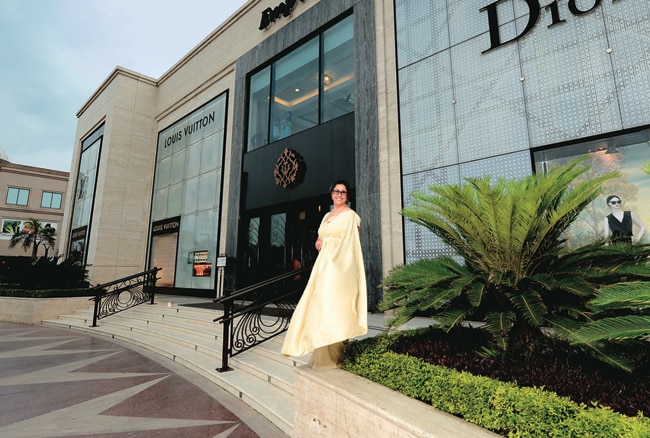 A mother and son walk through the entrance of the DLF Emporio Mall