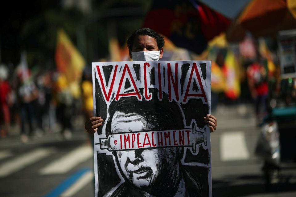A protestor holds a banner in anti-Bolsanaro rally. He has been criticised for his opinions on vaccines, environment, LGBTQ rights and a lot more. (photo-GETTY)
