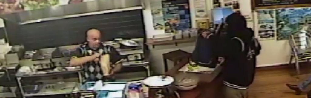 Cool as cucumber shop owner ignores armed robber, serves chicken instead