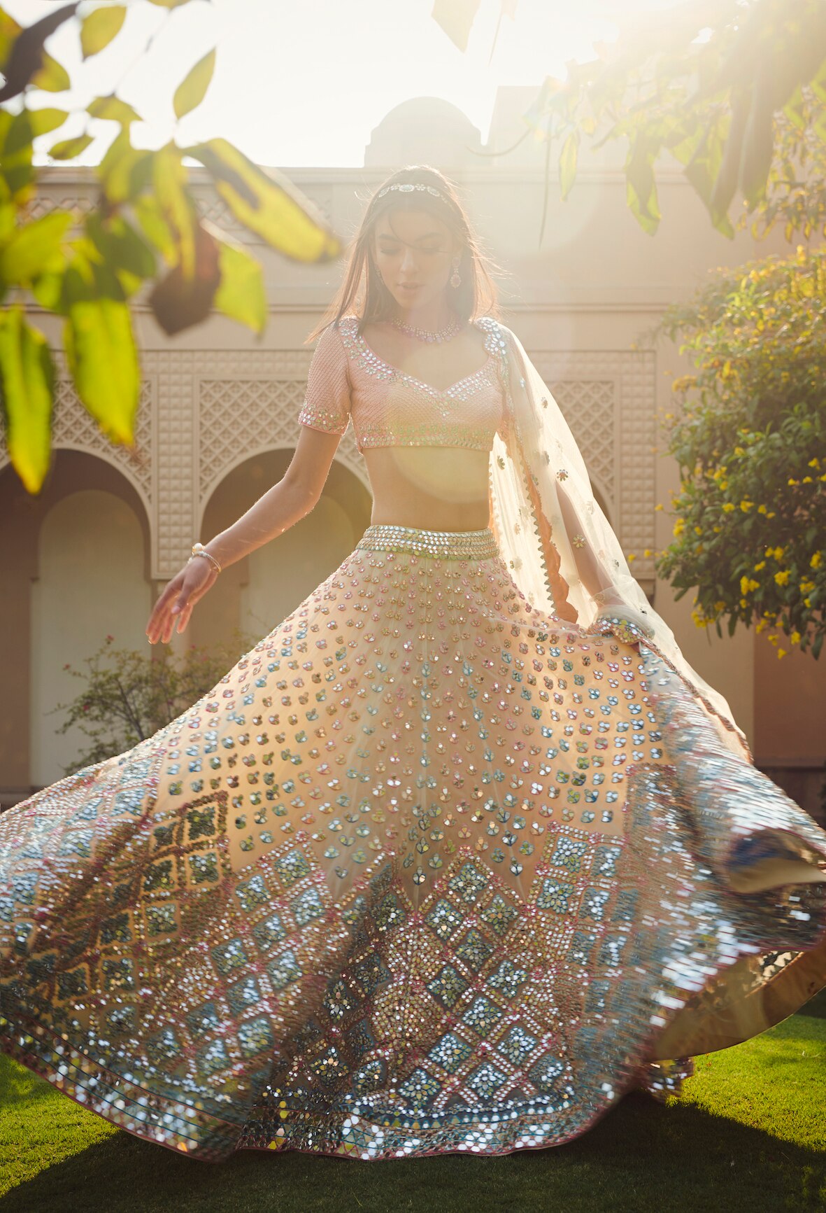 A perfect combination of peach and coral lehenga with iridescent mirror work
